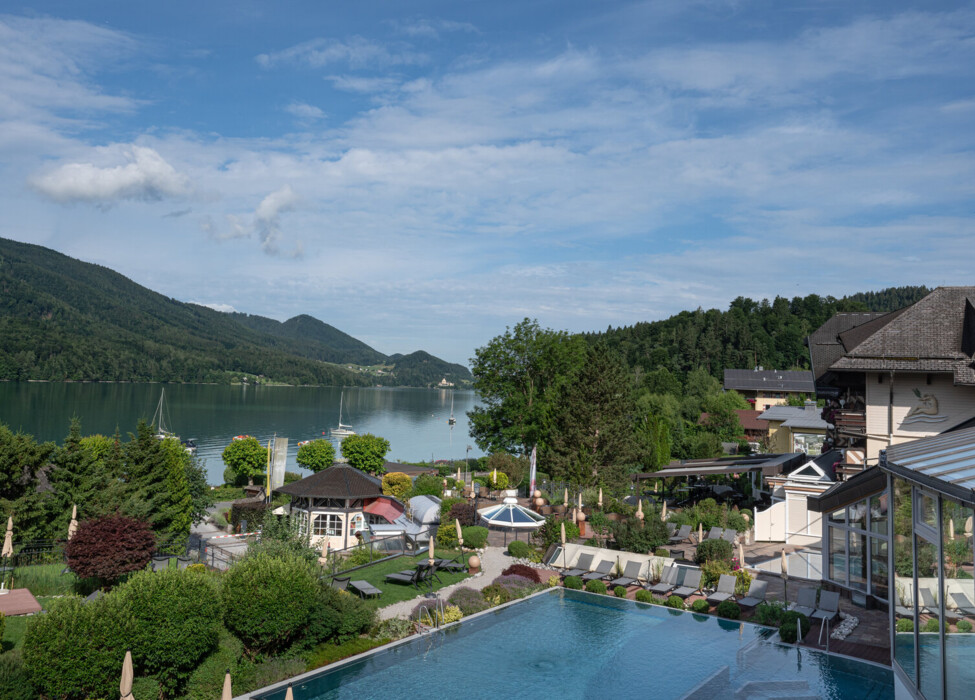 Panoramablick auf das 4 Sterne Superior Hotel Ebner's Waldhof am See mit dem Fuchlsee im Vordergrund.