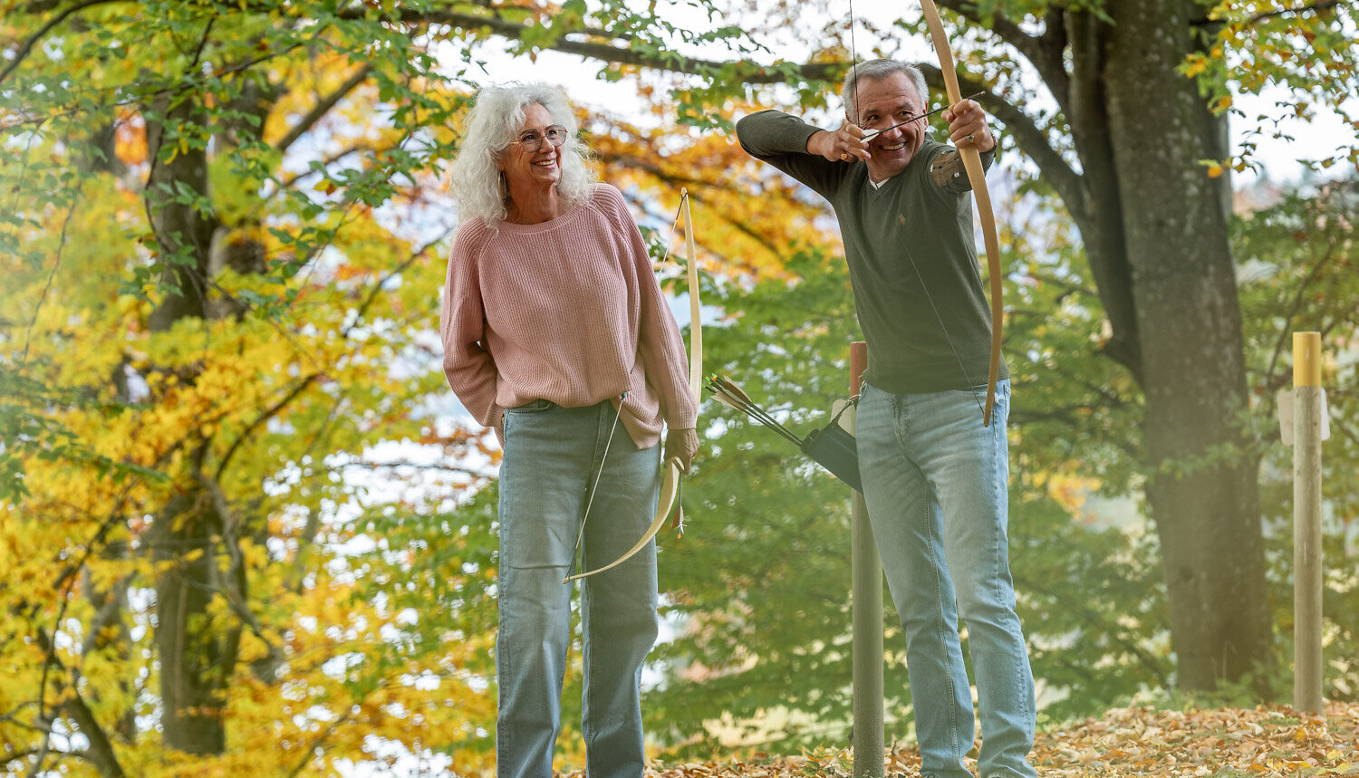 Pärchen in der Wiese liegend auf einer Alm im Aktivurlaub am Fuschlsee, Salzburg.