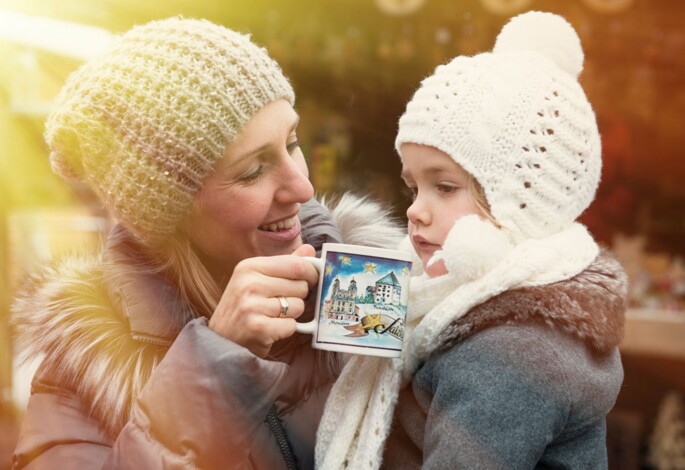 Mutter mit Kind auf einem Adventmarkt im Salzkammergut.