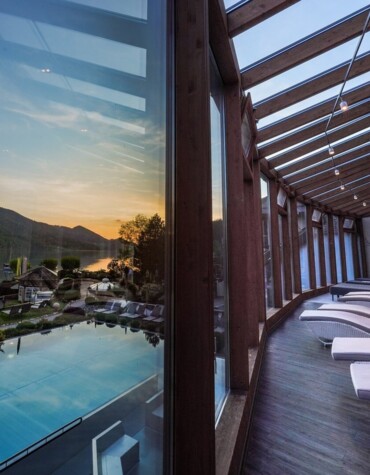 Eine Dame genießt die Ruhe und den Parnoramablick auf den Fuschlsee im Ruheraum des Spa im Hotel Ebner's Waldhof.