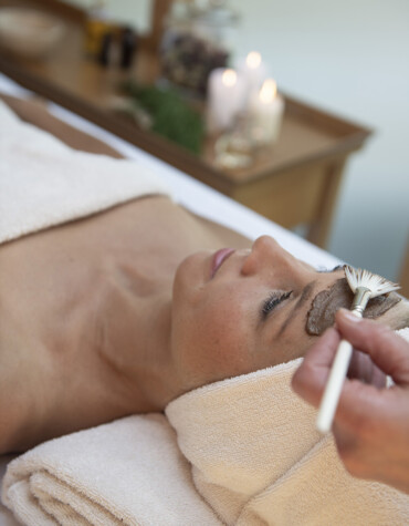 A person receiving a relaxing facial treatment with a brush.