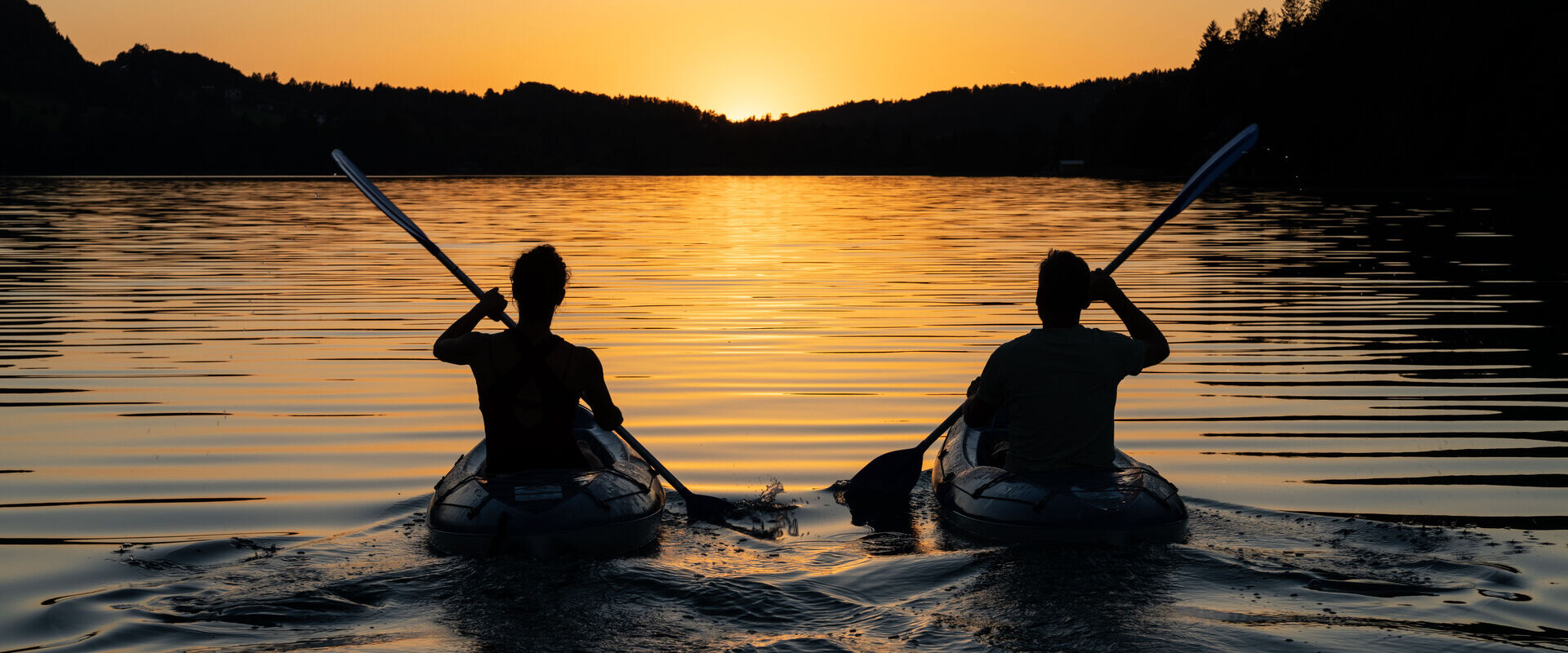 Pärchen beim Radfahren mit Blick auf den Fuschlsee im Salzkammergut.