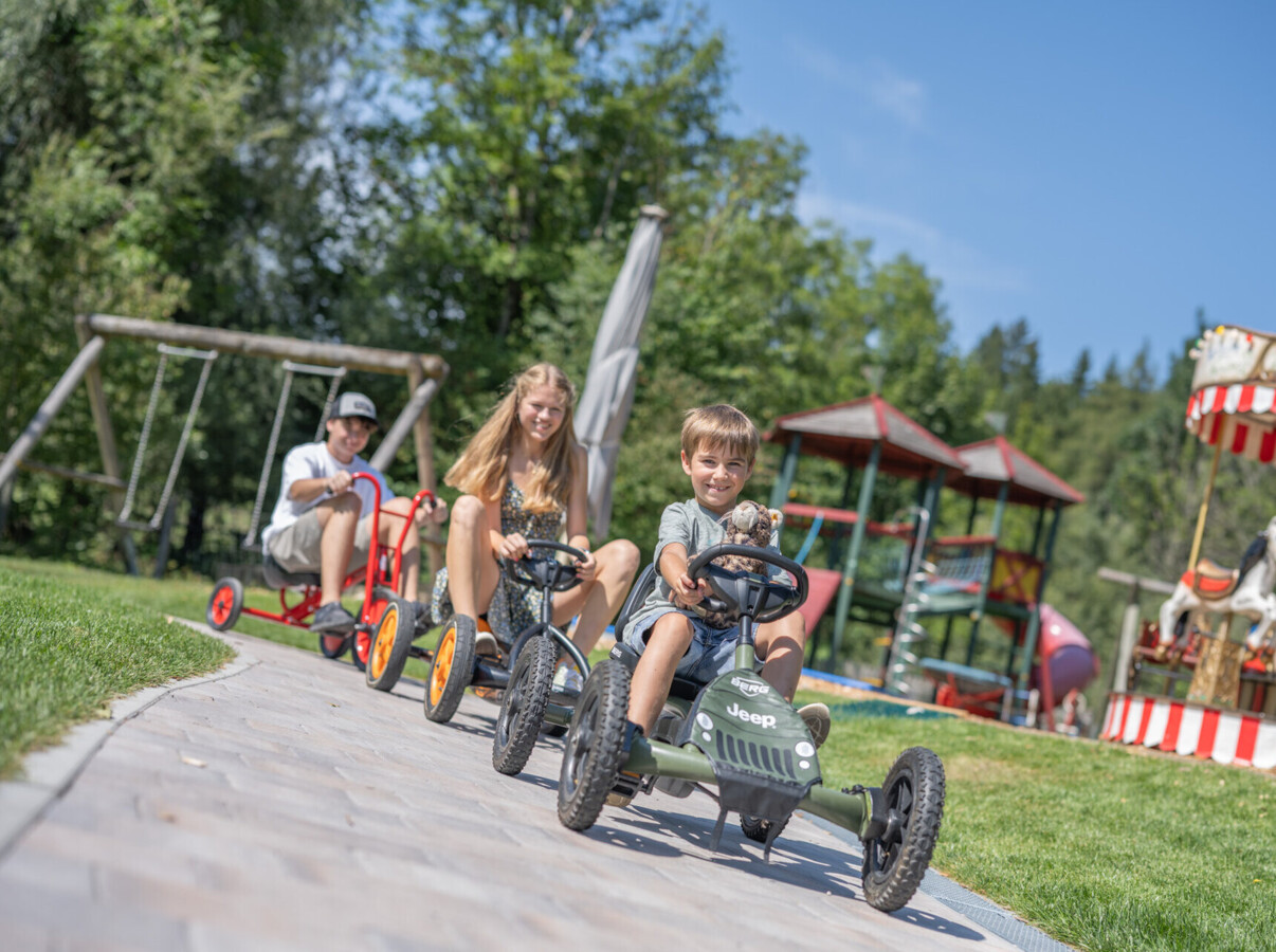 Kinder mit Go-Karts im Familienhotel Waldhof Fuschlsee Resort.