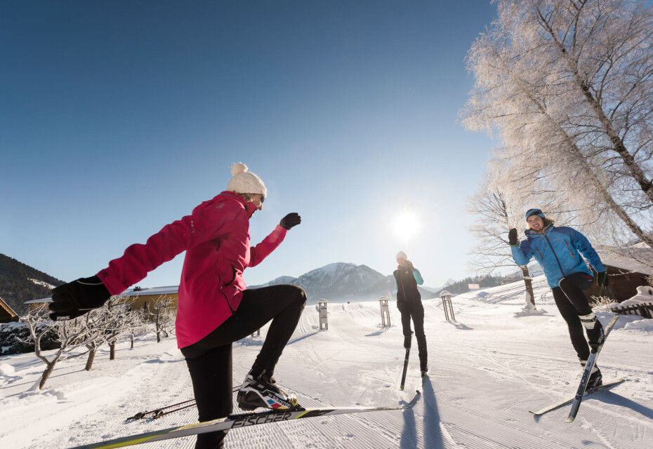Langläufer bei Aufwärmübungen mit einem Langlauflehrer am Fuschlsee.