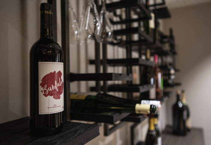 Weinflasche mit Regal im Hintergrund in einem stilvollen Weinkeller im Waldhof Fuschlsee.