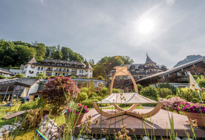 Der großzügige Garten mit Liegemöglichkeiten im Sommer mit Blick auf das Hotel Ebner's Waldhof am Ufer des Fuschlsee.