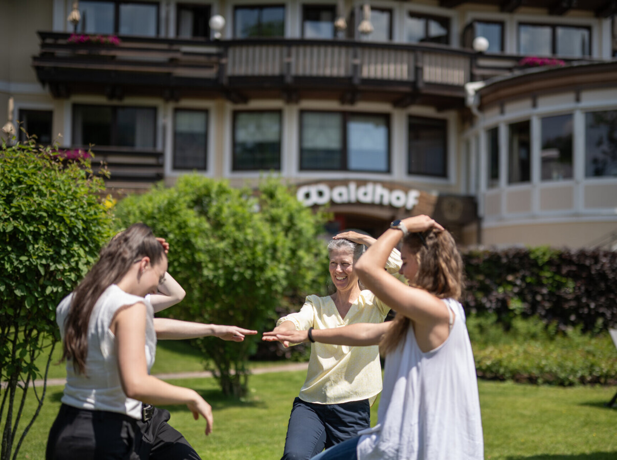 Group enjoying activities on the lawn at Waldhof Fuschlsee Resort.