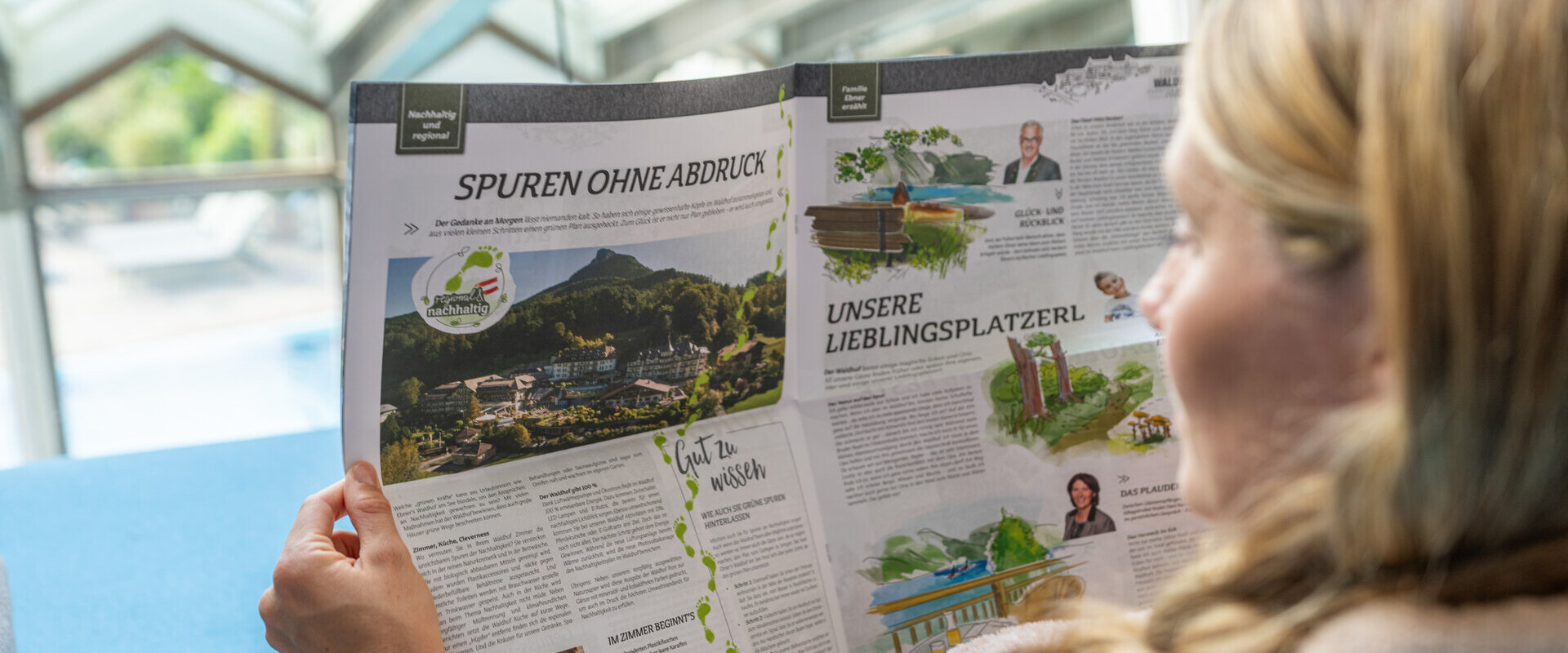 A person reading a magazine featuring scenic landscapes and sustainability topics indoors.