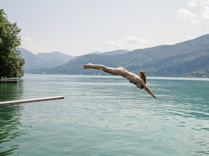 Junge Dame in gelben Sommerkleid am Ufer des Fuschlsee.