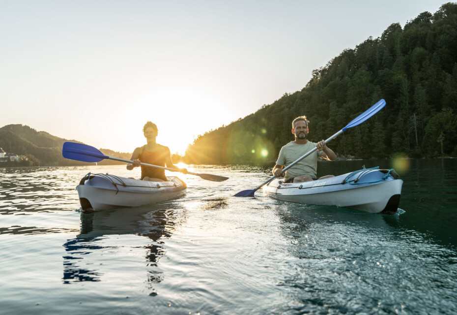 Two people kayaking on lake Fuschl at sunset.