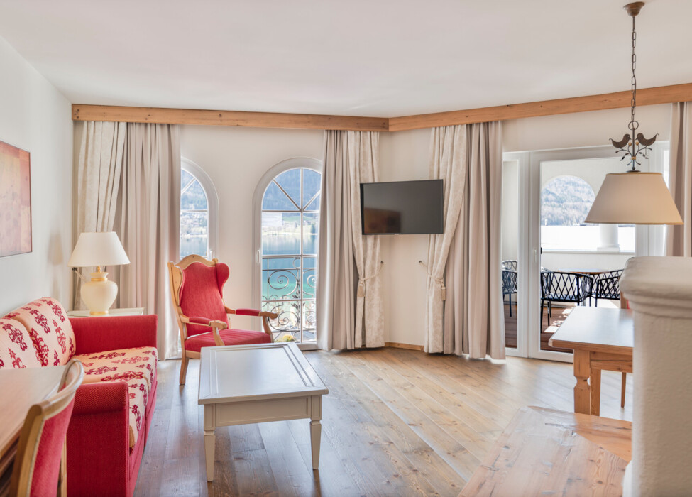 Bright living room with elegant furniture, arched windows, and a view of the lake.