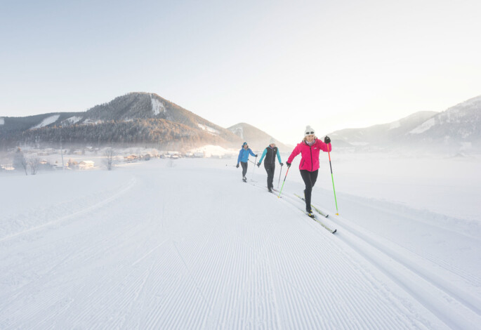Dame beim Schlittenfahren im Winter-Aktivurlaub am Fuschlsee, Salzkammergut.