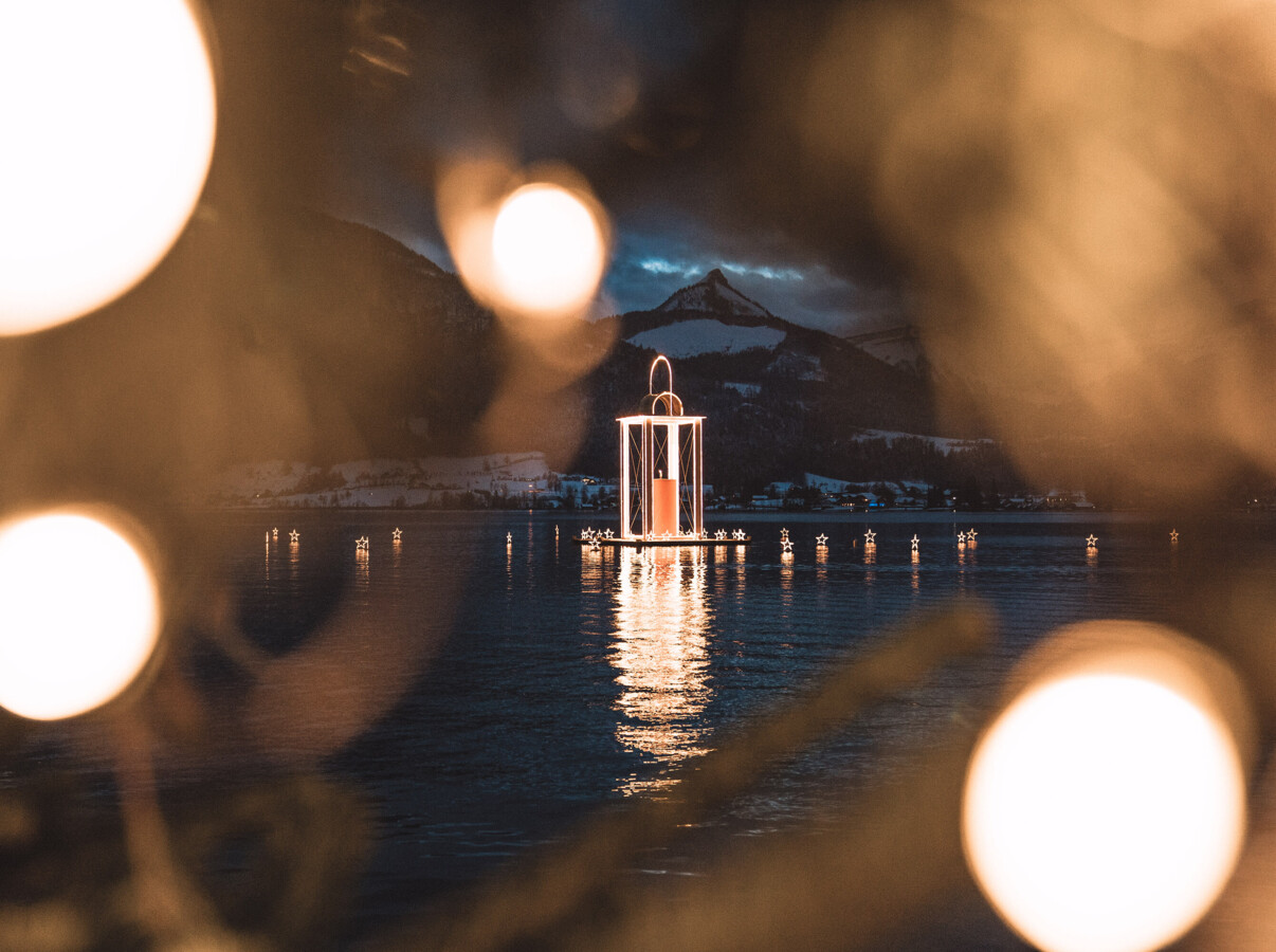 Die berühmte schwimmende Advent-Kerze mit schwimmenden Sternen in St. Wolfgang am Wolfgangsee.