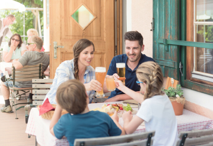 A family enjoys drinks at an outdoor cafe, sharing a cheerful moment.