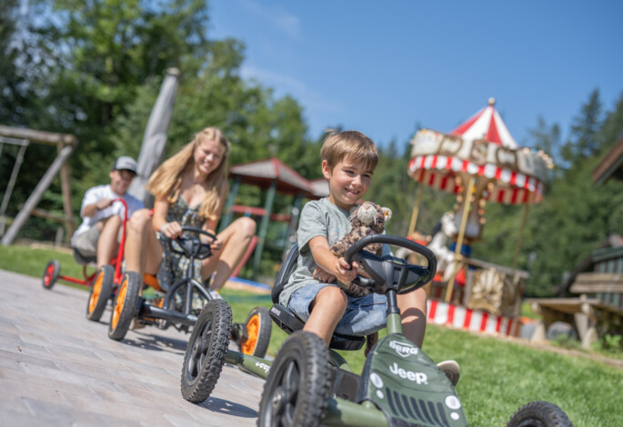 Kinder mit Go-Karts im Familienhotel Ebner's Waldhof am See.