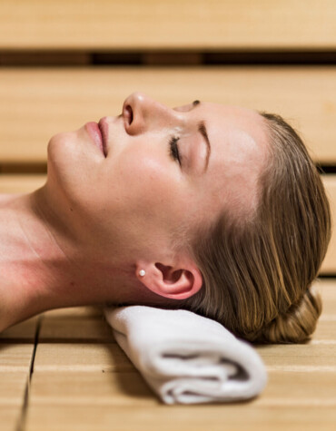 Junge Dame beim Entspannen in einer der Saunen im Wellnesshotel Ebner's Waldhof am See.