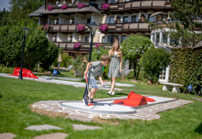 Familie beim Minigolfspielen auf dem hoteleigenen Minigolfplatz