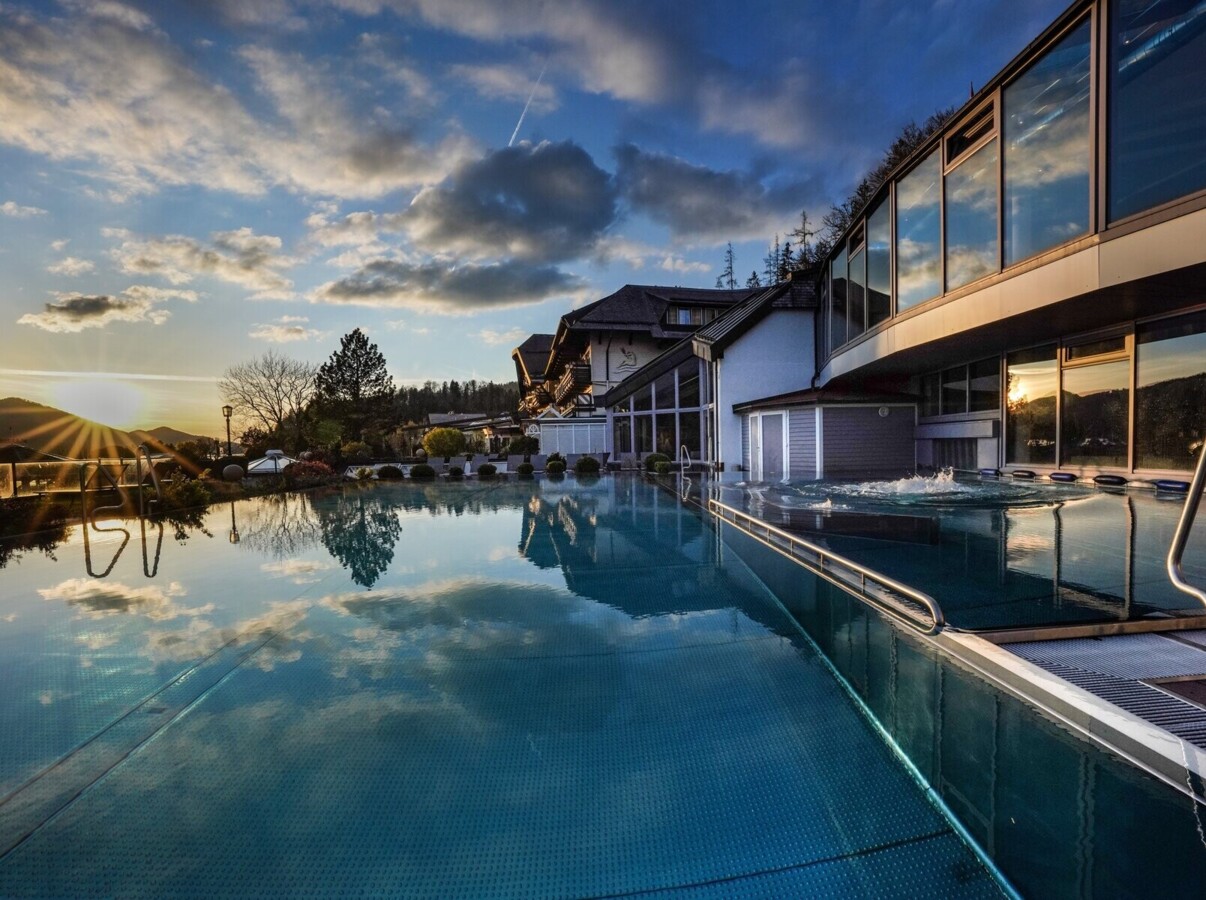 Outdoor pool reflecting the sunset and clouds.