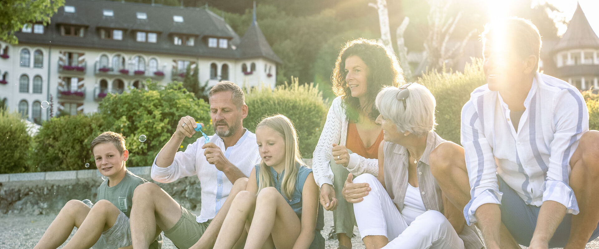 Familie beim Picknick im Sommer am Seeufer des Fuschlsee.