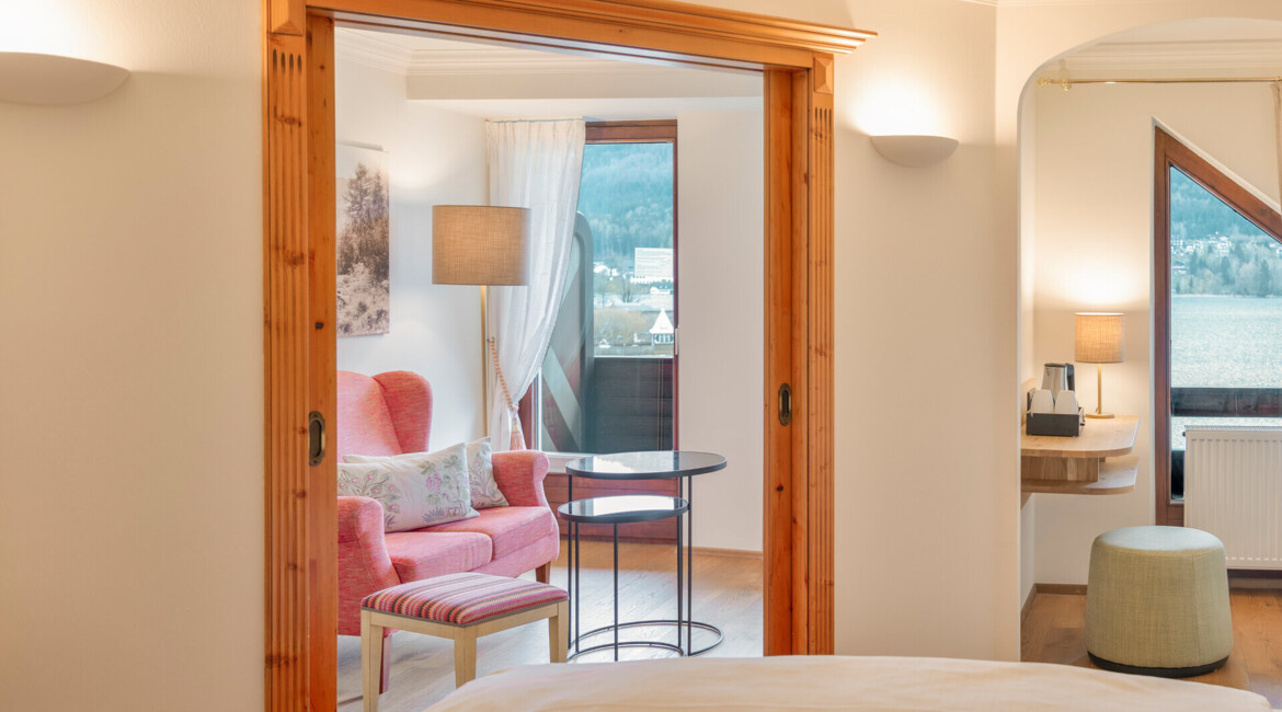 Cozy hotel room with a seating area, large windows, and natural light.