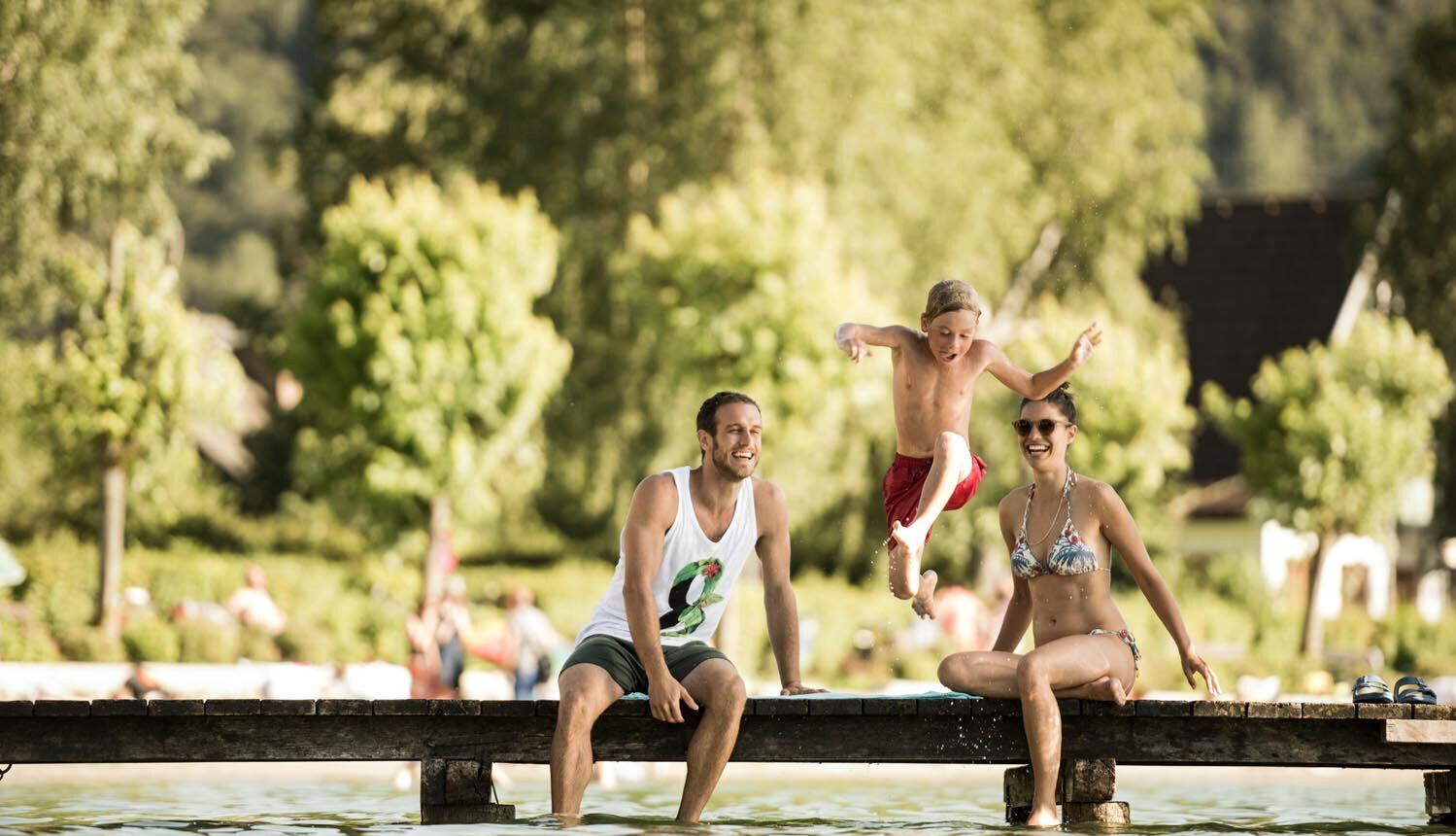 Badeurlaub mit Kindern am See - Kind springt vom Steg in den Fuschlsee.