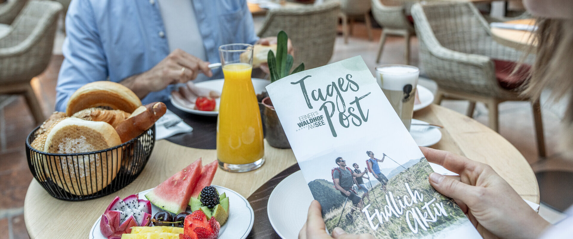 Junger Mann beim Frühstück im Gourmethotel Ebner's Waldhof am Fuschlsee.