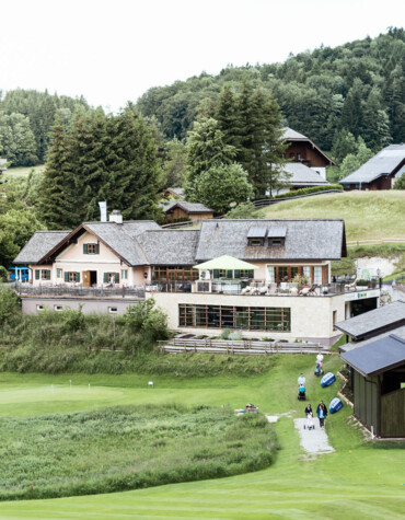 Golf course at Waldhof Fuschlsee Resort with clubhouse and surrounding greenery.