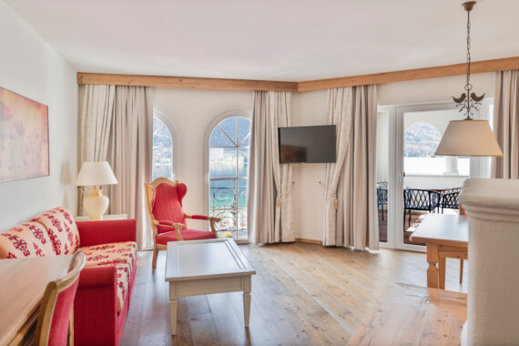 Bright living room with elegant furniture, arched windows, and a view of the lake.