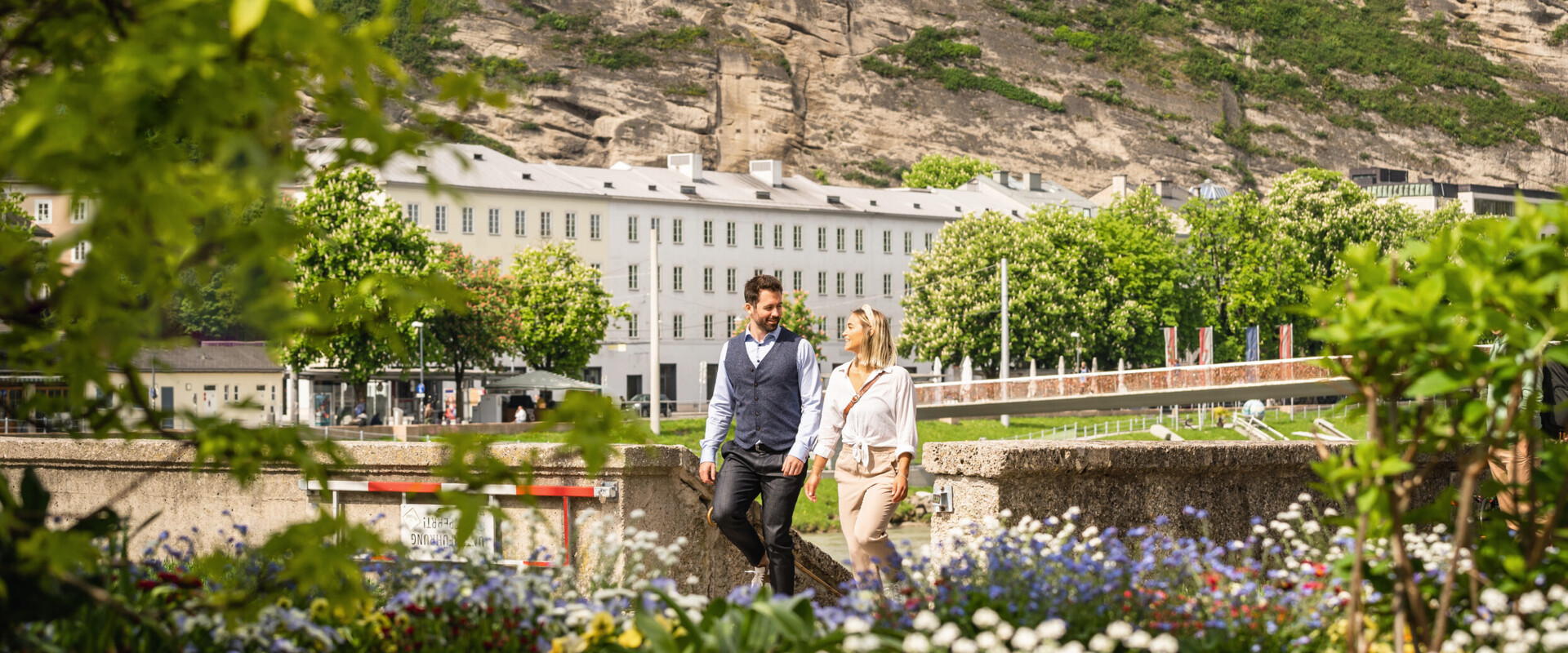 Pärchen spaziert in der Stadt Salzburg eine Treppe an der Salzach hoch.