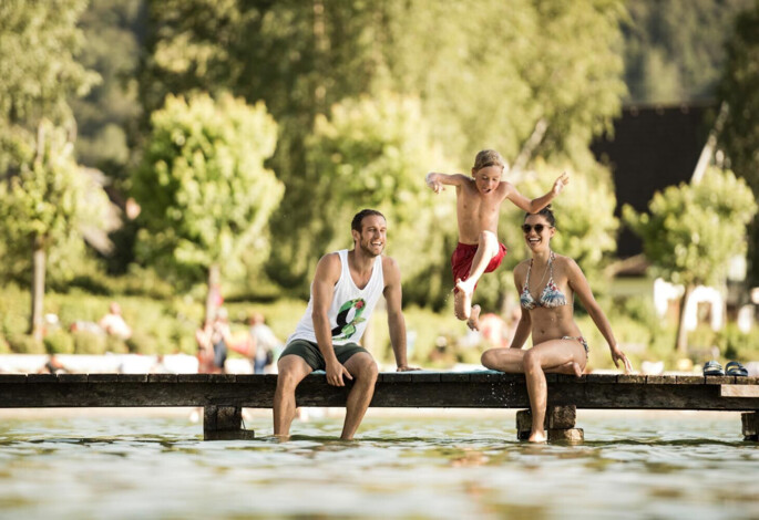 Badeurlaub mit Kindern am See - Kind springt vom Steg in den Fuschlsee.