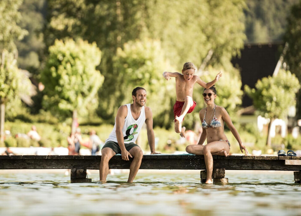 Badeurlaub mit Kindern am See - Kind springt vom Steg in den Fuschlsee.