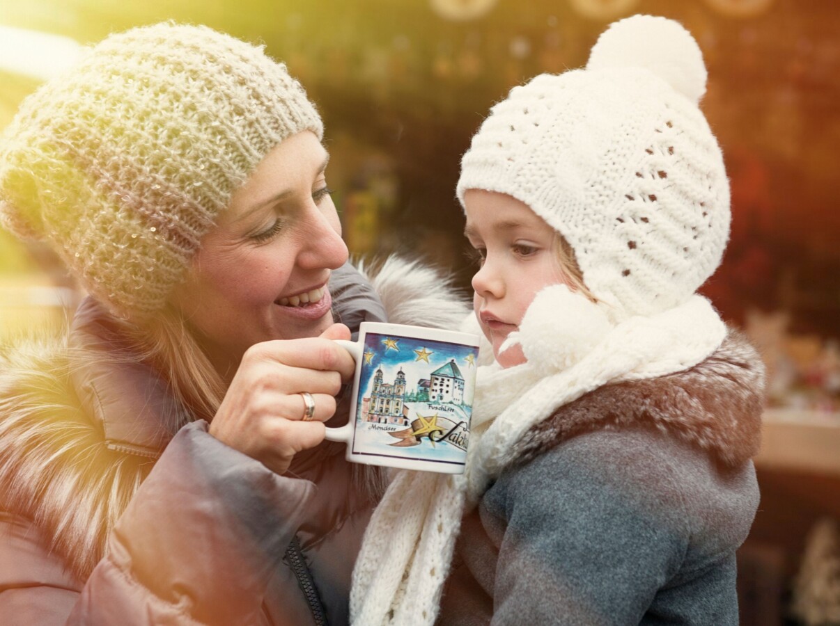 Mutter mit Kind auf einem Adventmarkt im Salzkammergut.