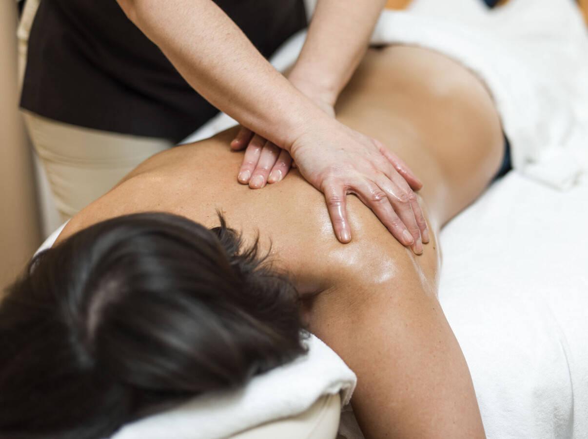 A person receiving a relaxing back massage at Waldhof Fuschlsee Resort. 