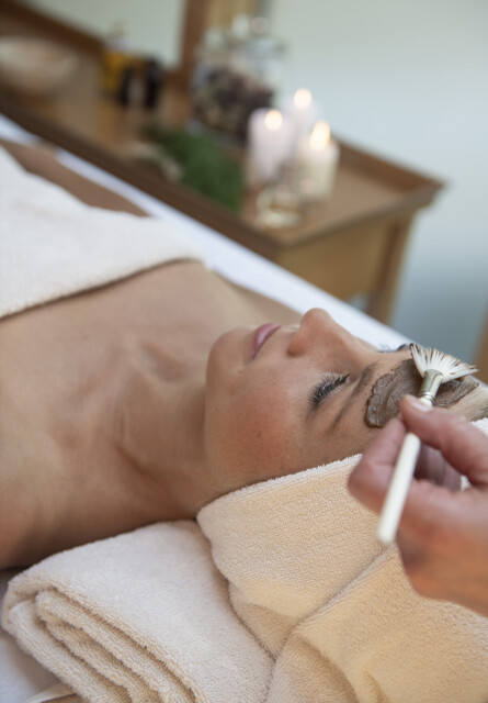 A person receiving a relaxing facial treatment with a brush.