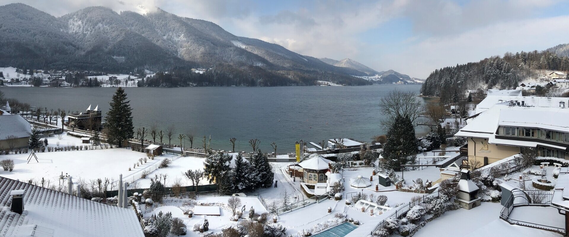 Das 4* Superior Waldhof Fuschlsee Resort mit Schnee und Außenpool.