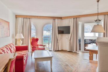 Bright living room with elegant furniture, arched windows, and a view of the lake.