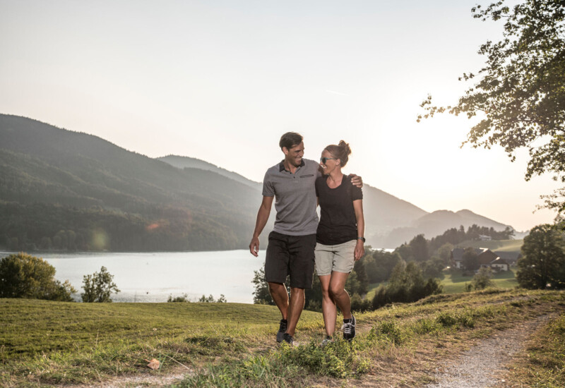 Pärchen beim Wandern am Fuschlsee-Rundweg im Sommer.