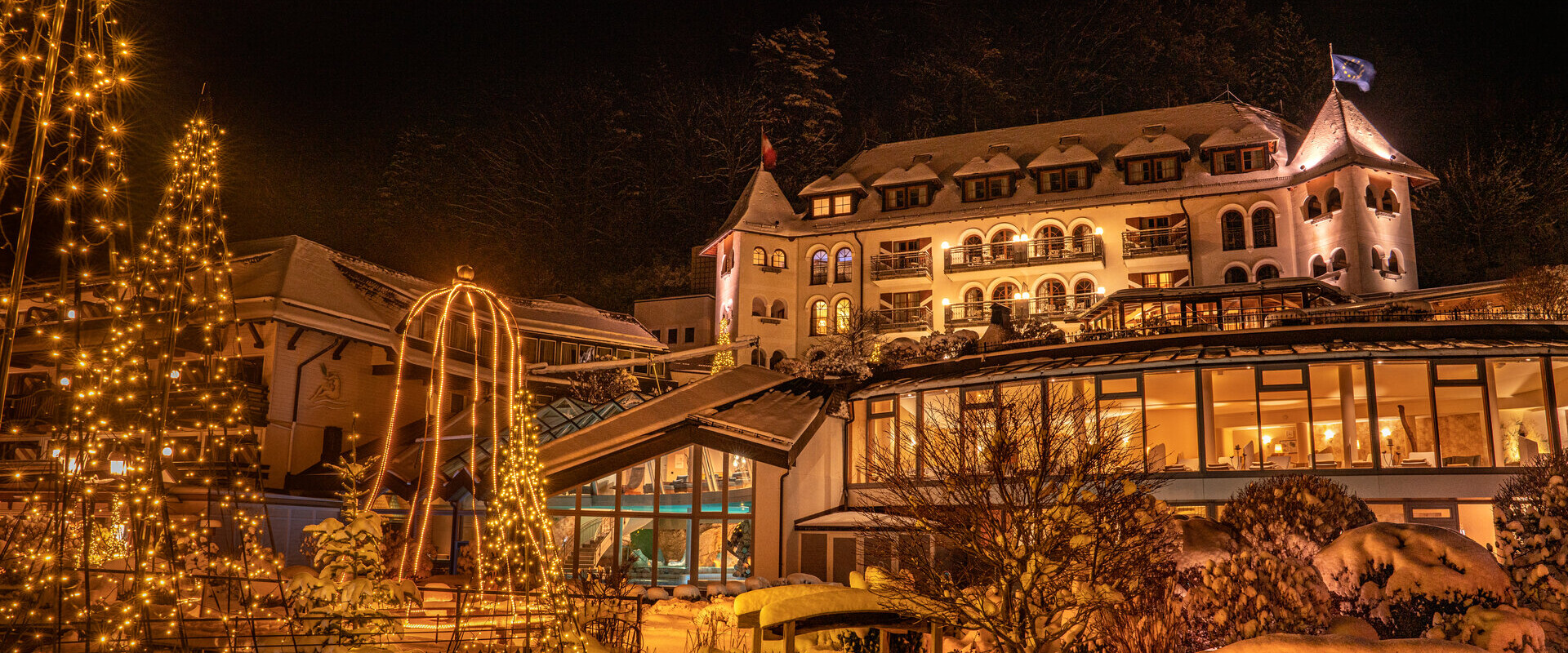 Blick auf den tief verschneiten Waldhof im Winter bei Abendstimmung.